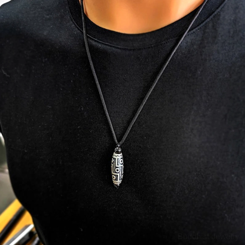 Buddhist protection necklace wearing close-up on black shirt demonstrating daily casual wear style