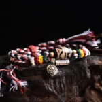 Nine-eye dzi bead Om Mani Padme Hum copper adjustable Buddhist prayer bracelet with multicolor woven rope and metal pendants