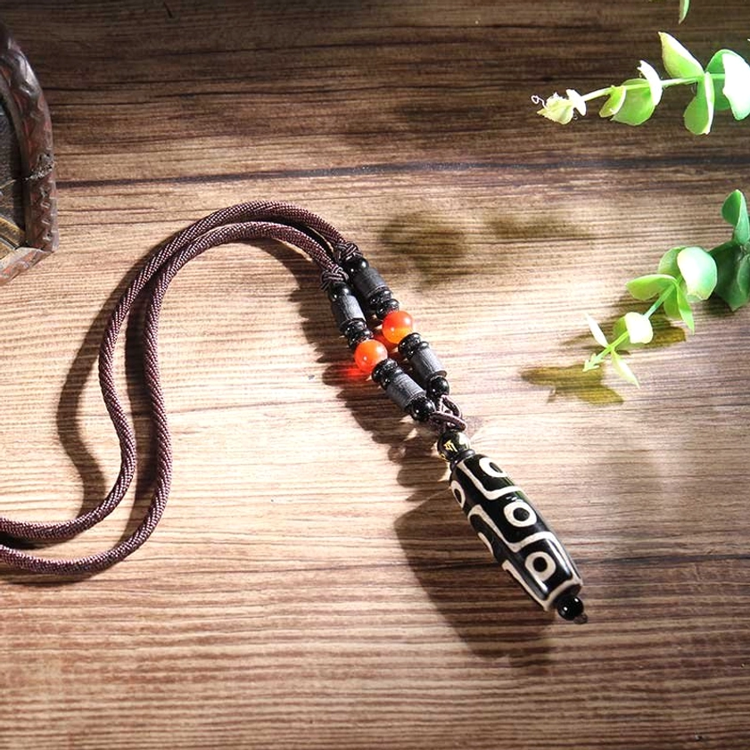 Nine-eye dzi bead pendant with black-white pattern on brown cotton cord with spacer beads