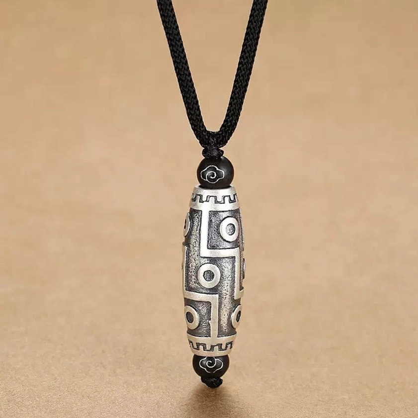 Nine-eye dzi bead pendant full view highlighting the complete engraved pattern and copper craftsmanship