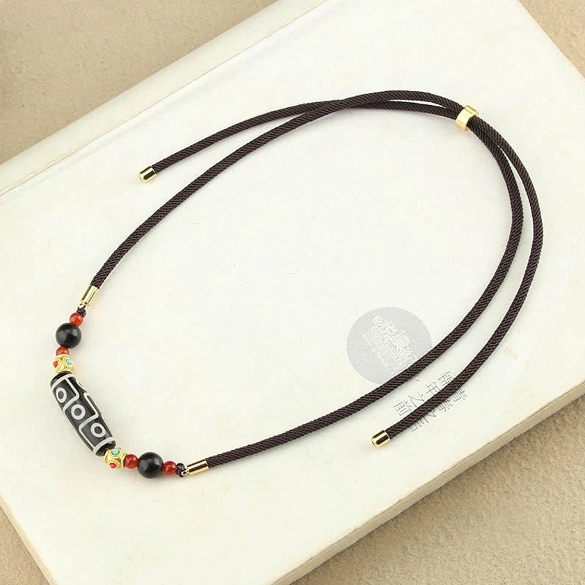 Nine-Eye Dzi Buddhist pendant necklace overhead view with tiny accent beads and easy-adjust clasp mechanism