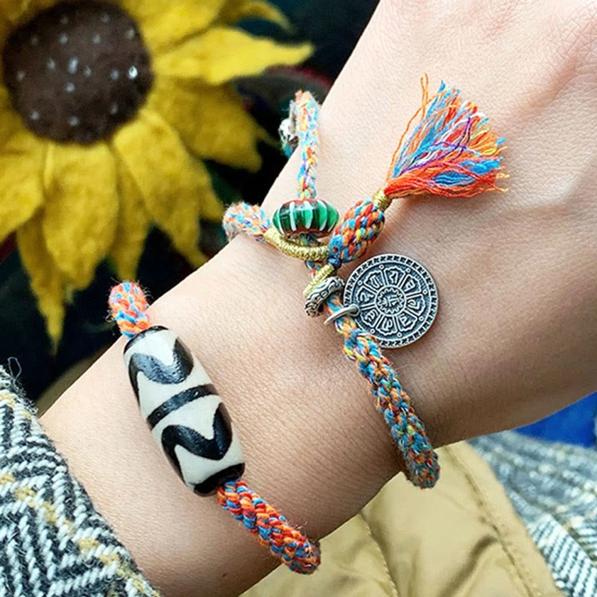 Nine-Eye Dzi Bead Sterling Silver Om Mani Padme Hum bracelet detail shot showing hand-painted dzi bead and sacred mantra charm