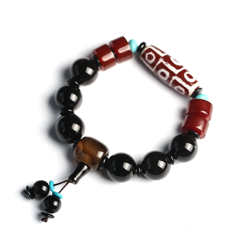 Handmade nine-eye dzi bracelet with protective black onyx beads in studio lighting with natural elements