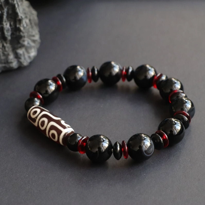 Nine-Eye Dzi Bead Black Onyx Bracelet elevated frontal view on dark background