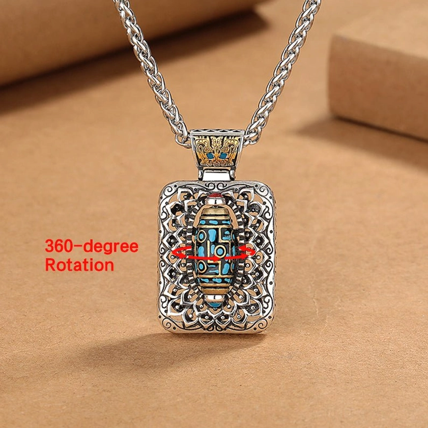 Nine-Eye Dzi Bead rotatable necklace pendant with 360-degree rotation feature labeled, showing vintage copper and decorative stone inlays