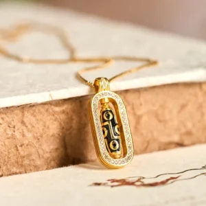 24k gold plated nine-eye dzi bead pendant necklace with rotatable agate stone and CZ encrusted frame, overhead view on vintage wooden surface