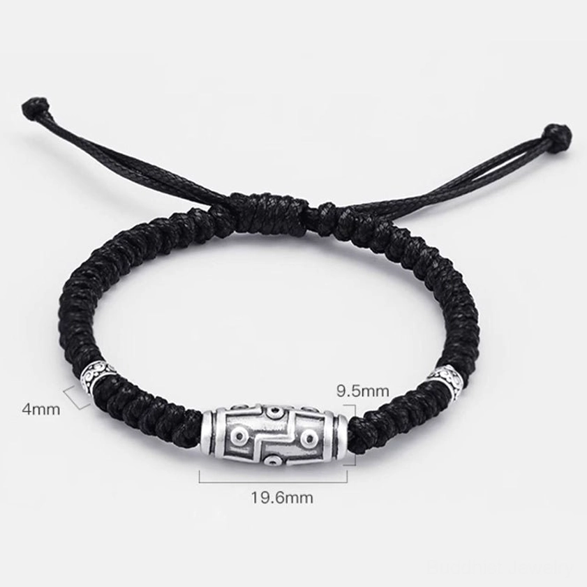 Artistic studio photography of 999 sterling silver nine-eye dzi bead bracelet on artistic backdrop highlighting craftsmanship
