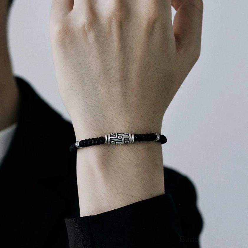Sterling silver nine-eye dzi bead bracelet worn on wrist, demonstrating fit and real-world wear styling