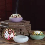 Nine-tailed fox liuli crystal incense burner set displayed overhead with assembled and disassembled pieces, showing lavender and jade green jade-style bases with gold-trimmed cloisonne lids and rising incense smoke
