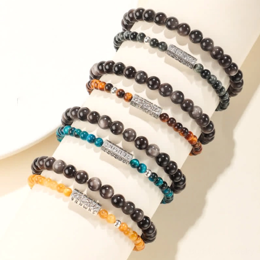 Close-up detail of silver sheen obsidian beads and engraved Om Mani Padme Hum charm on double wrap protective Buddhist bracelet