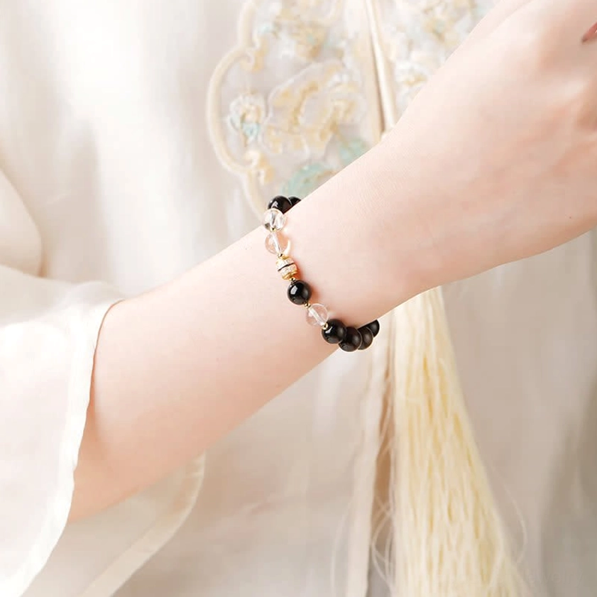 Silver Sheen Obsidian protection bracelet worn on wrist with traditional clothing background, displaying daily wear styling