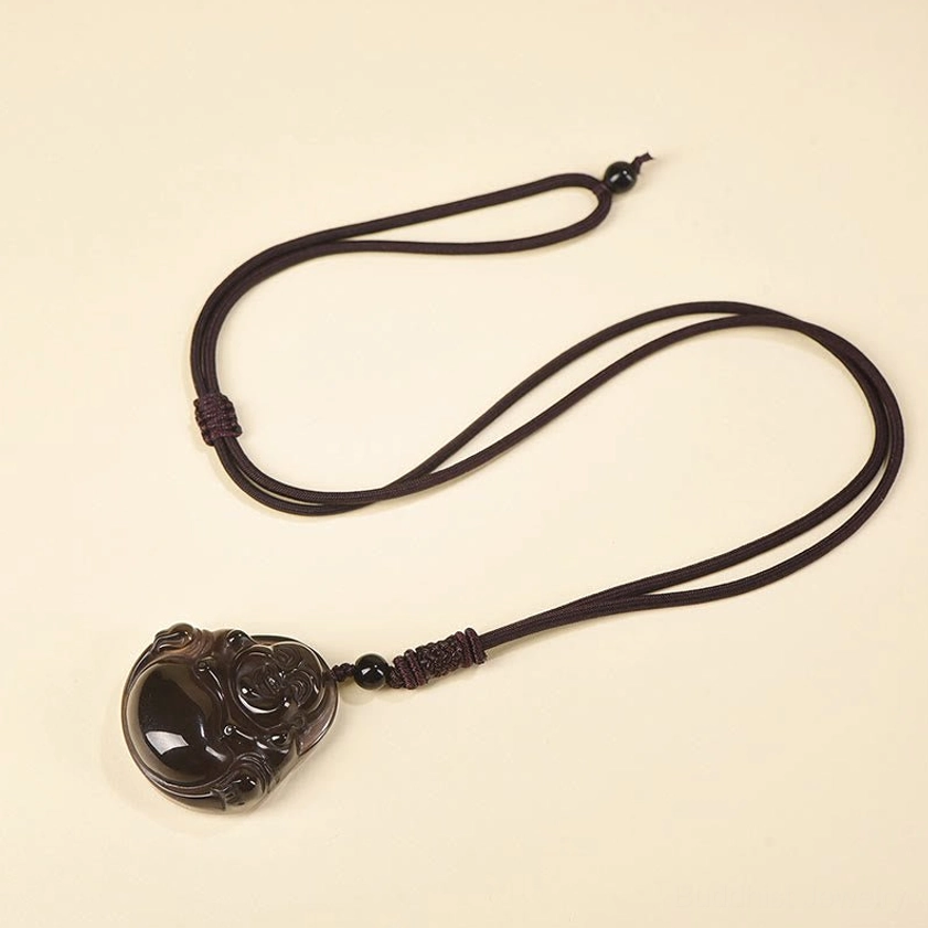 Buddha pendant braided necklace with adjustable brown woven rope knot flat lay top-down view