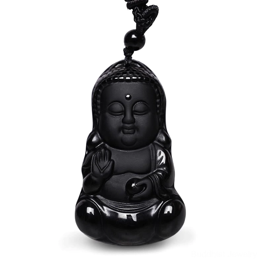 Close-up detail of carved black obsidian Buddha pendant with decorative bead on cord