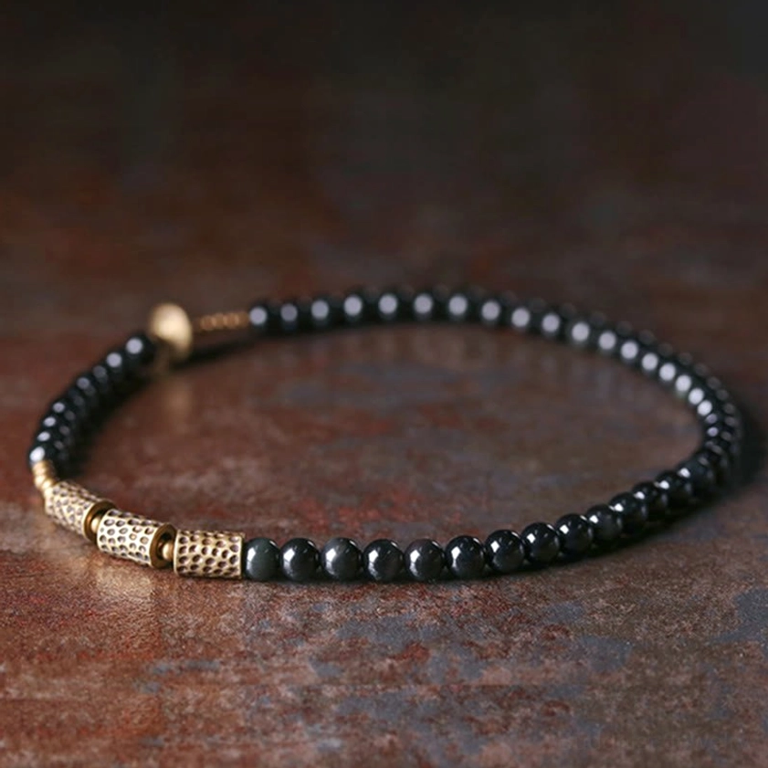 Rainbow obsidian double wrap bracelet worn on adult wrist with denim fabric background, neatly fitted showing casual daily styling versatility