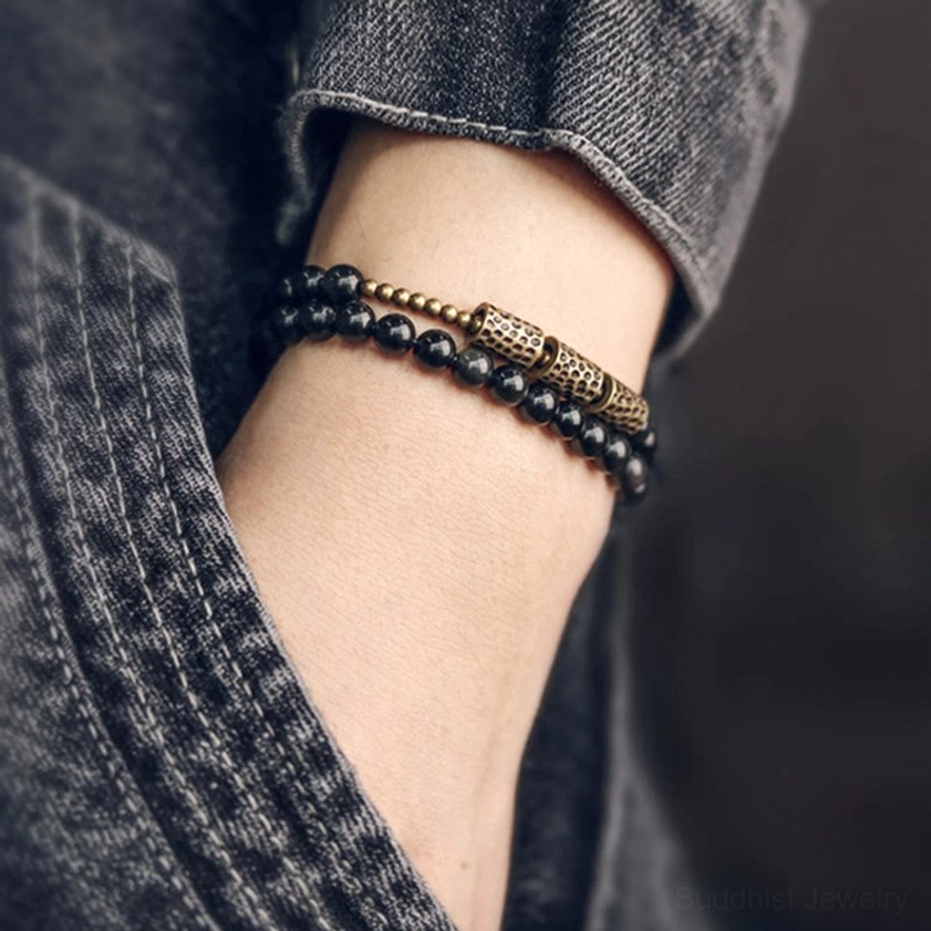 Rainbow obsidian double wrap bracelet worn on wrist with denim background, casual styling showing black and bronze tone design