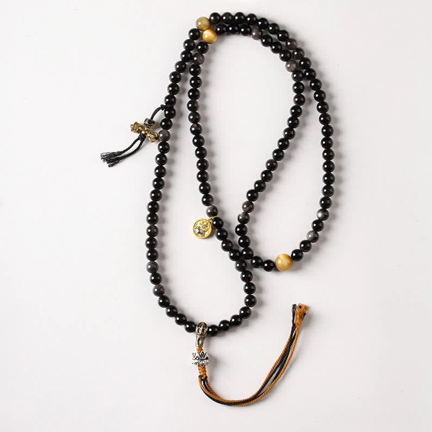 Double-strand Silver Sheen Obsidian Buddhist mala necklace with Garuda charm flat lay on light background