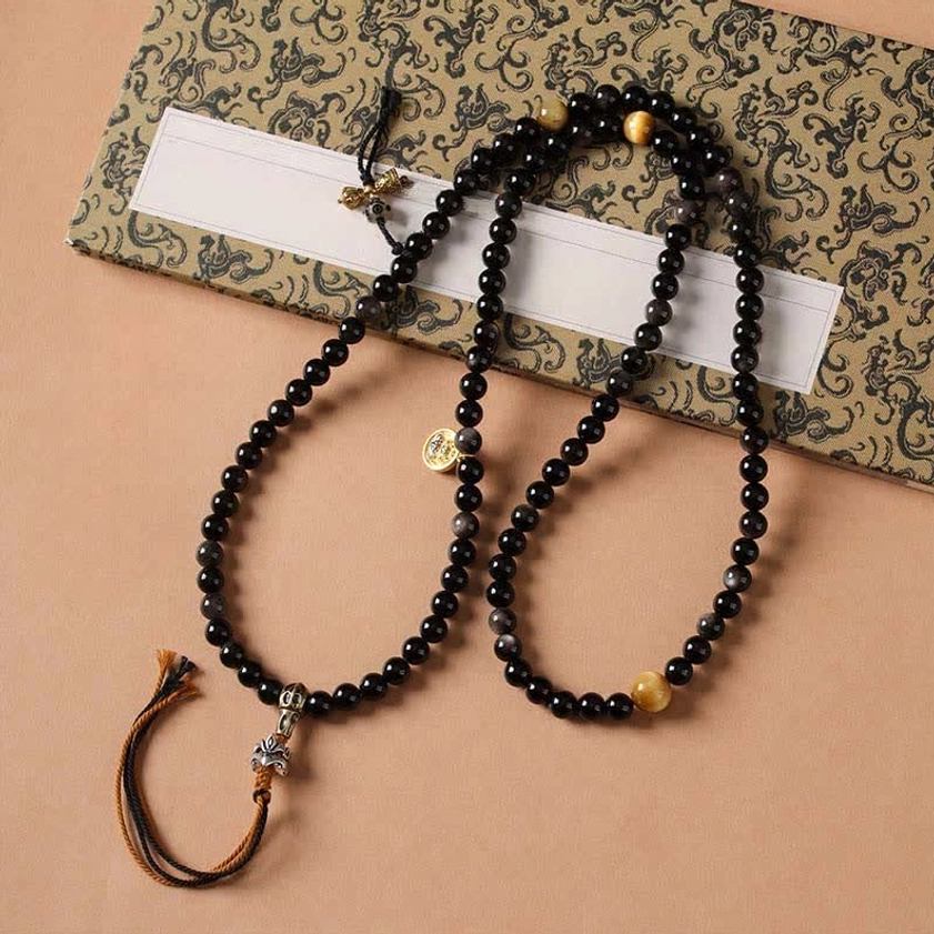 Two Silver Sheen Obsidian Buddhist protection necklaces displayed in elegant gift box with metal charms