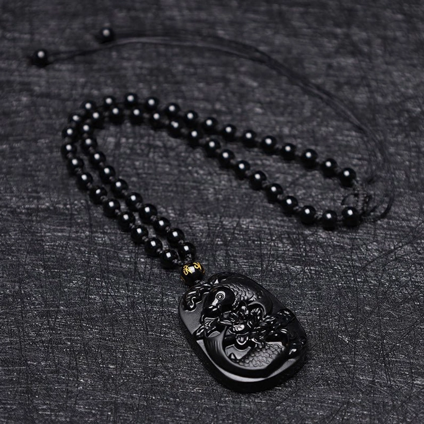 Black Obsidian Koi Lotus Beaded Necklace - overhead flat lay on dark fabric showing full pendant and adjustable chain