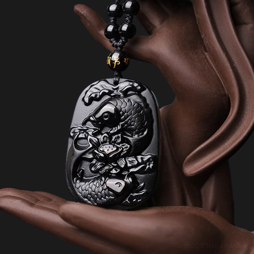 Black Obsidian Koi Fish Lotus Necklace being held in hand - size reference showing polished carved pendant details