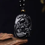 Black Obsidian Koi Fish Lotus Pendant Necklace - overhead flat lay showing carved relief details and beaded chain