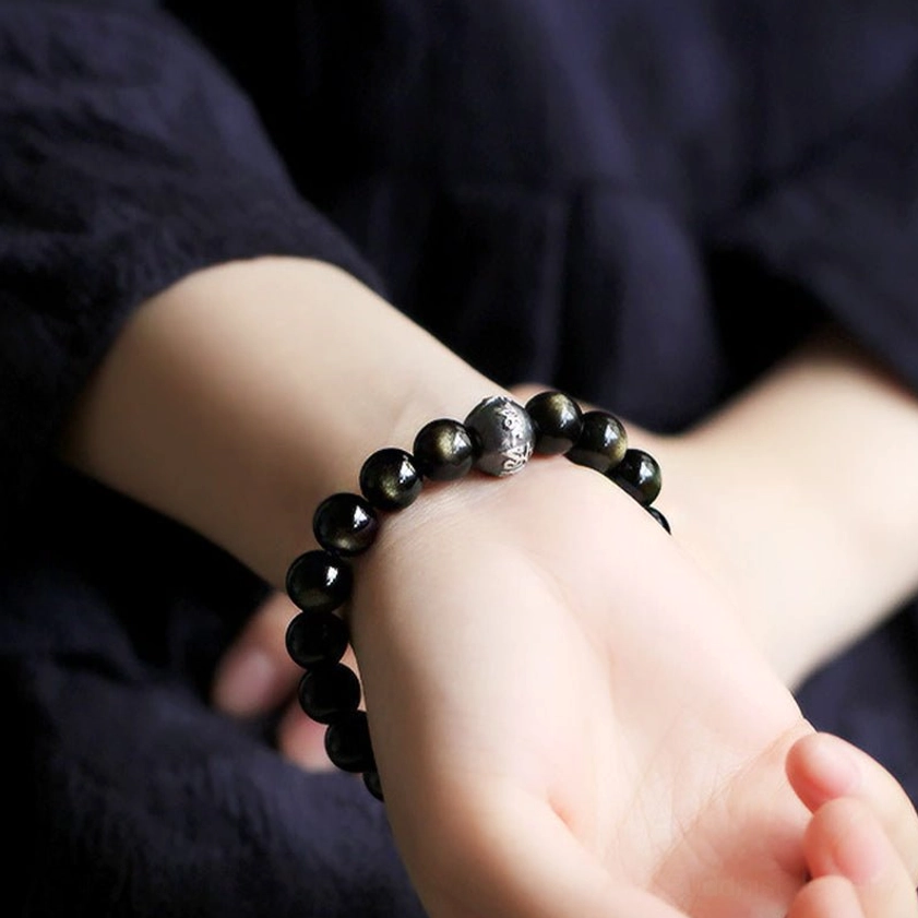 Person wearing obsidian zodiac Buddha bracelet on wrist showing daily wear styling