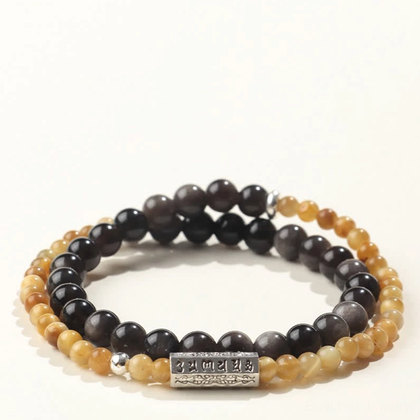 Flat lay view of silver sheen obsidian Buddhist mantra bracelet with light gradient beads, dark obsidian accents, and silver Om Mani Padme Hum charm against plain background