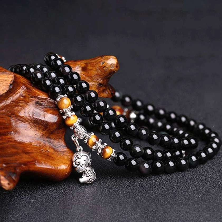 Buddhist prayer mala bracelet obsidian tiger eye beads side angle view with silver spacers