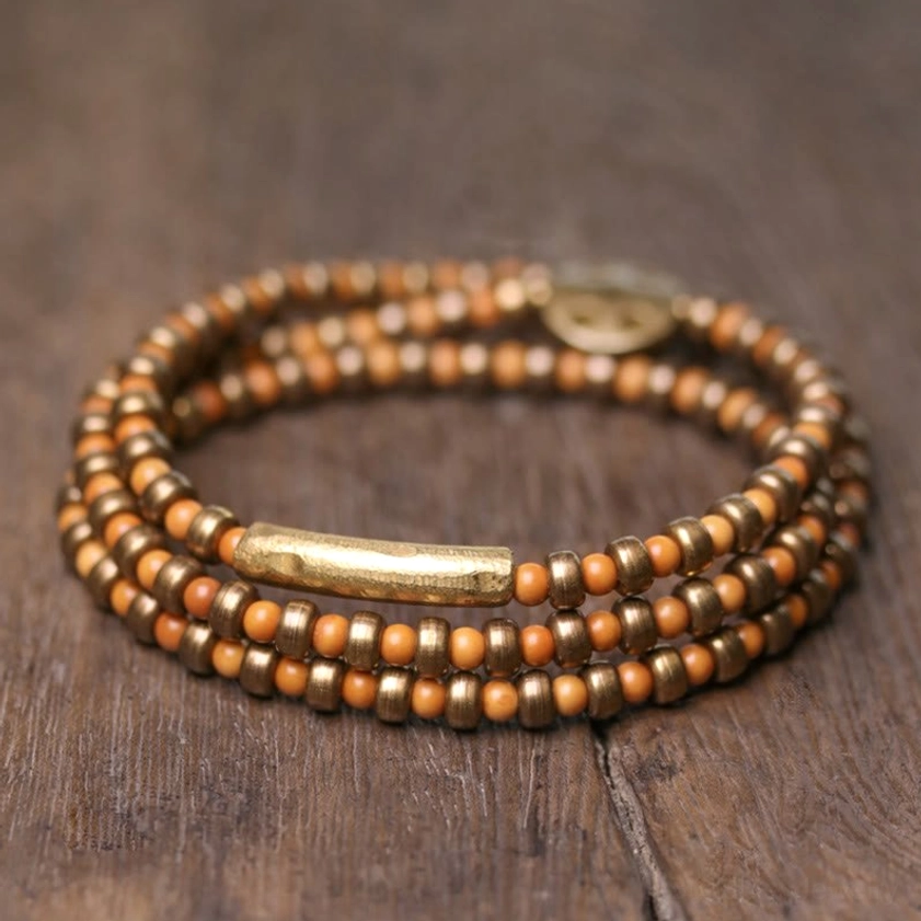 Copper Buddhist bracelet featuring natural olive pit beads and bronze decorative tube charm - top view