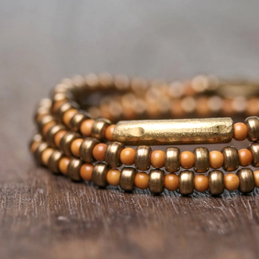 Close-up side view of handmade olive pit copper bracelet with antique bronze tube fastener