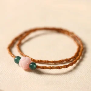 Olive pit lotus double circle bracelet flat lay top view showing bamboo-cut olive pit beads pink lotus bead and green jade accents