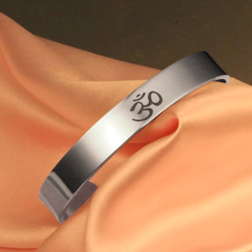 Buddhist OM engraved cuff bangle, side three-quarter perspective showing curved open design