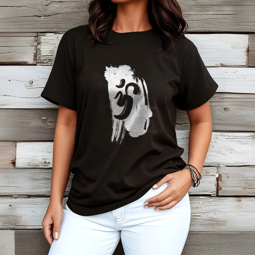 Female model wearing black Om Buddhist cotton t-shirt with white jeans on wooden wall background