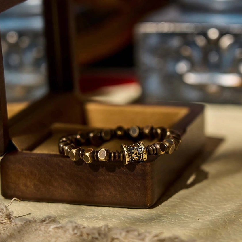 Handcrafted brass mantra bracelet displayed in wooden jewelry box for gift presentation