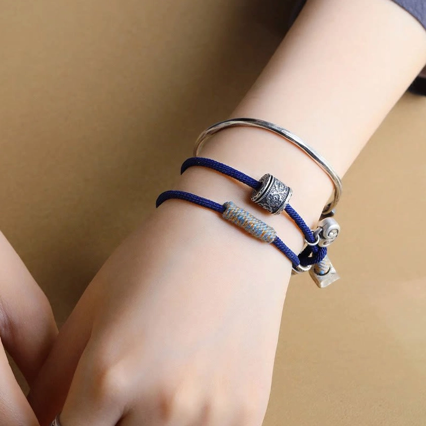 Double-wrap spiritual bracelet worn on wrist next to silver bangles, lifestyle photo