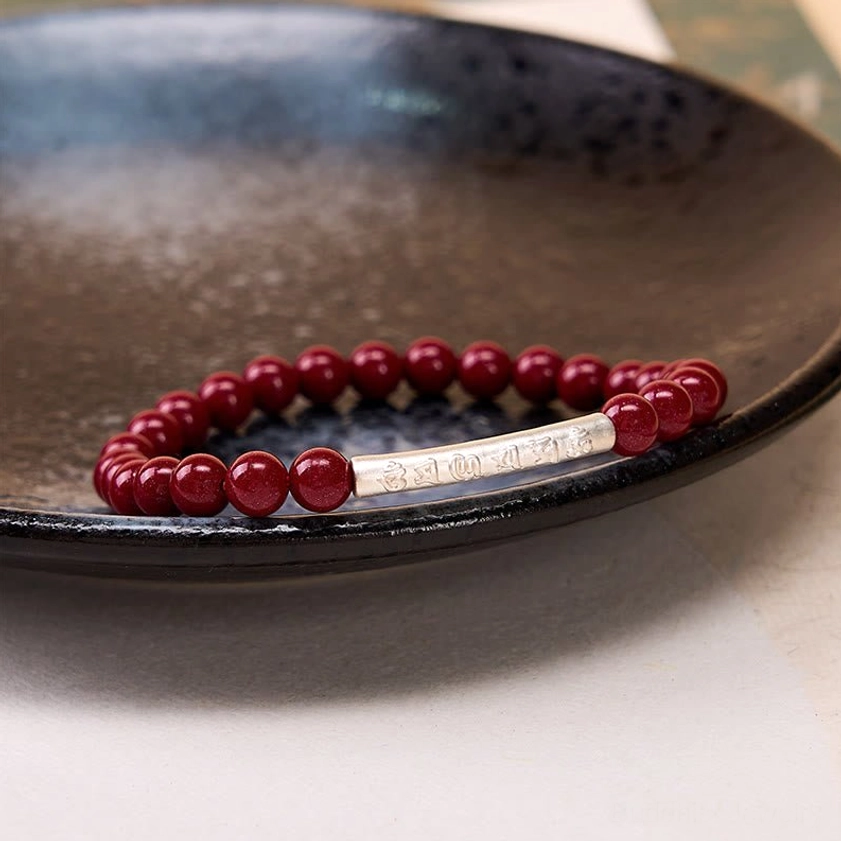 Om Mani Padme Hum wisdom bracelet with cinnabar stones, representing spiritual protection and compassion in Buddhist jewelry tradition