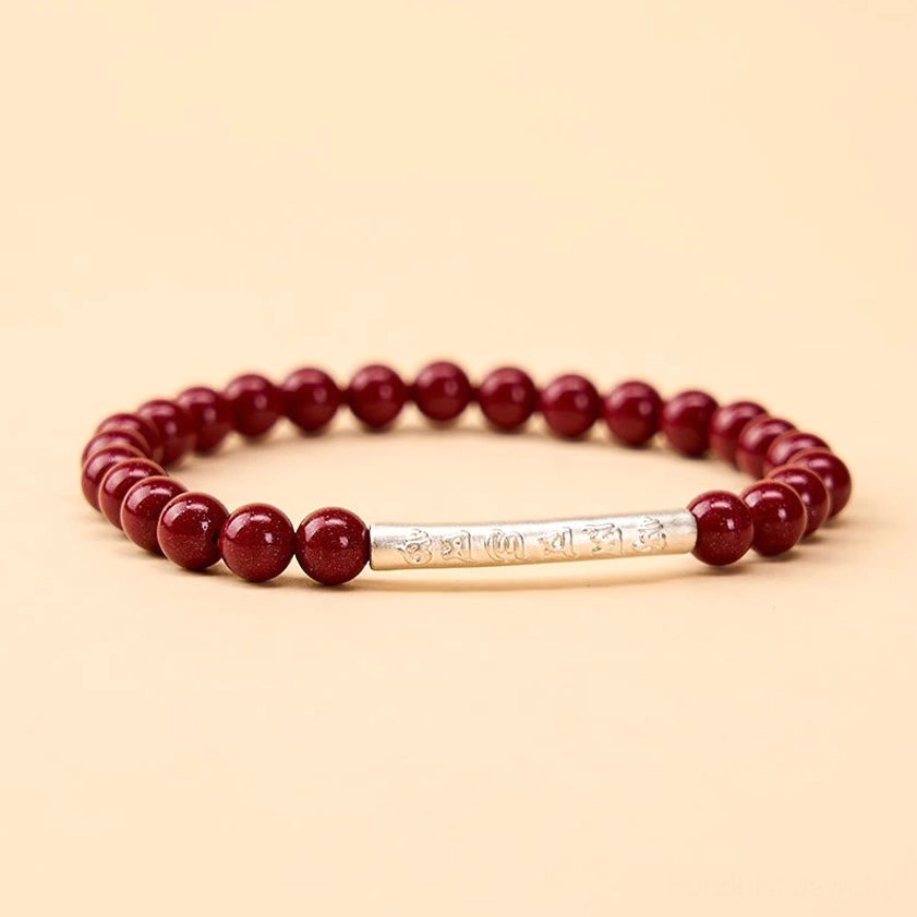 Om Mani Padme Hum cinnabar and sterling silver bracelet variation, showing deep crimson beads with polished silver mantra accent