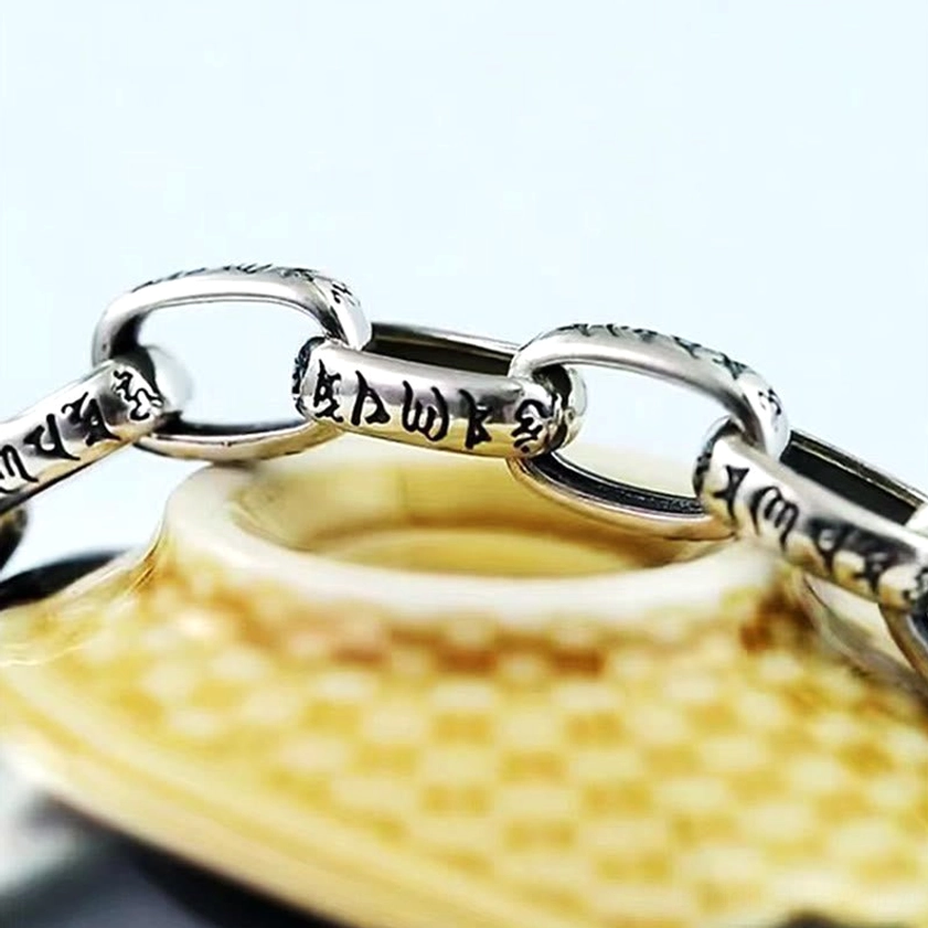 Om Mani Padme Hum copper bracelet chain and Double Dorje clasp detail, heavy silver-tone links with Buddhist engravings