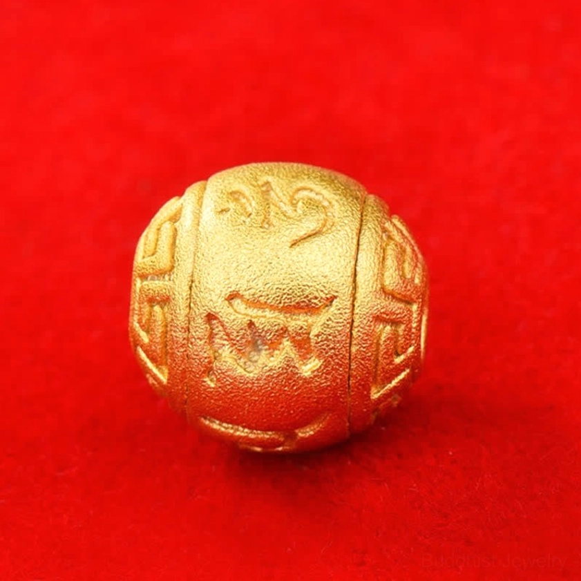 Engraved gold-toned mantra bead front view with sacred Om Mani Padme Hum text on solid red background