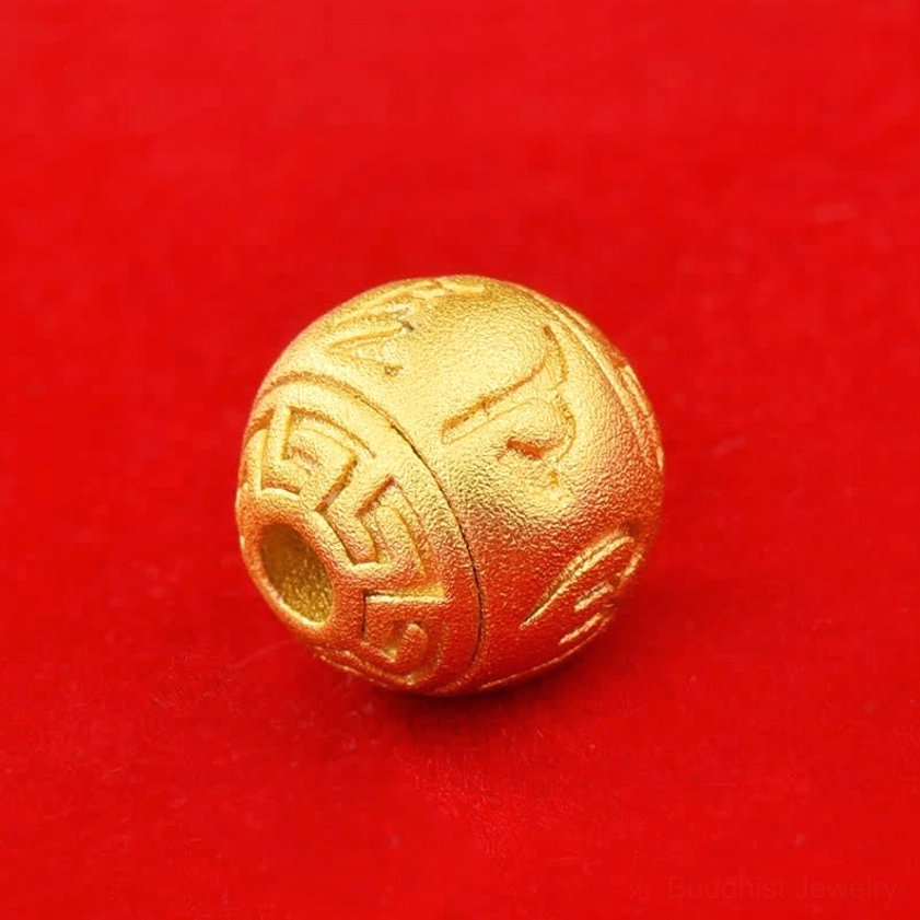 Engraved gold-toned sacred text bead side view showing geometric border patterns and drilled hole detail