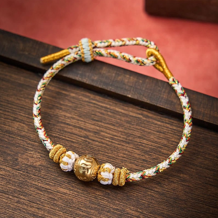 Om Mani Padme Hum mantra bracelet on dark wooden surface showing adjustable knot closure and engraved sacred text bead