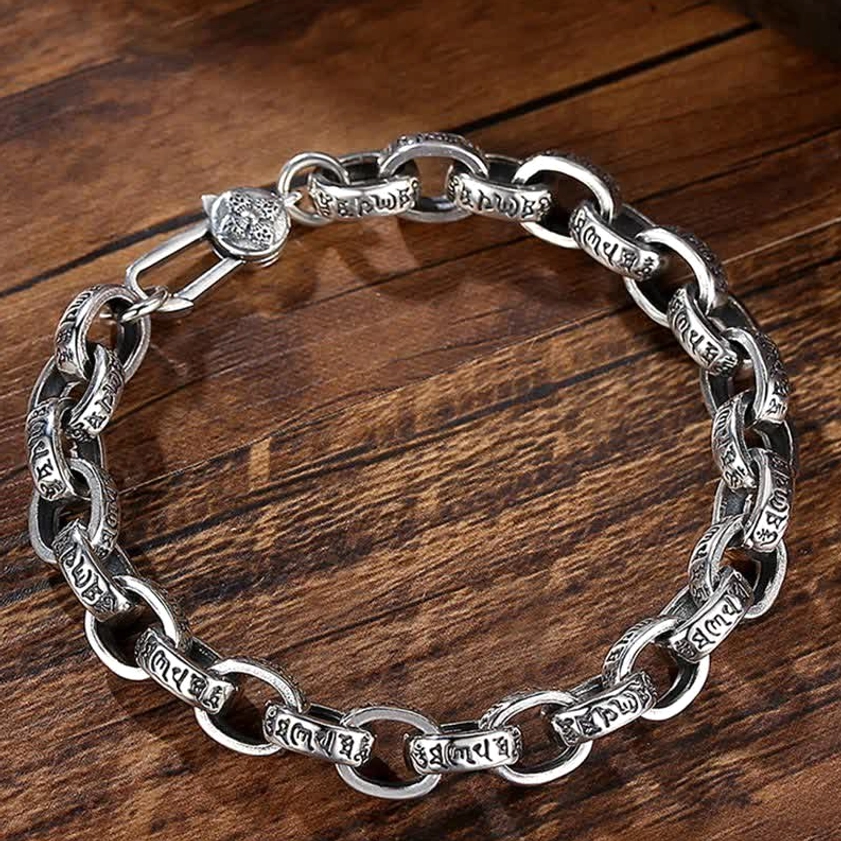 Flat lay view of sterling silver Om Mani Padme Hum Buddhist bracelet showing full mantra engraving on rounded cable chain links