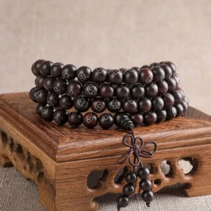 108-bead red sandalwood Om Mani Padme Hum prayer bracelet with sterling silver cloud inlays displayed on carved wooden stand