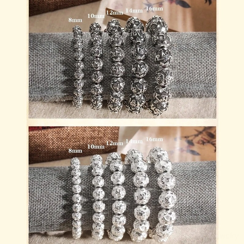 Detailed view of carved Om Mani Padme Hum beads showing intricate mantra engravings in silver alloy finish