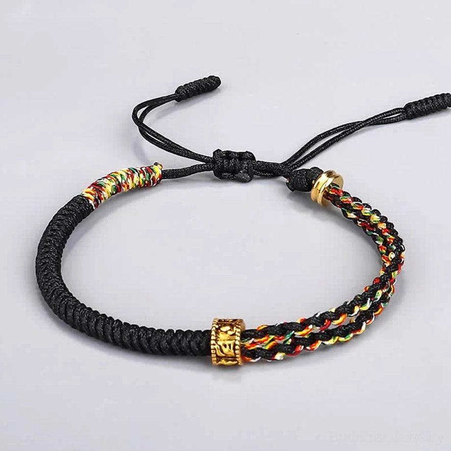 Om Mani Padme Hum black Buddhist string bracelet with colorful chakra-inspired braided accents and copper mantra bead flat lay photography