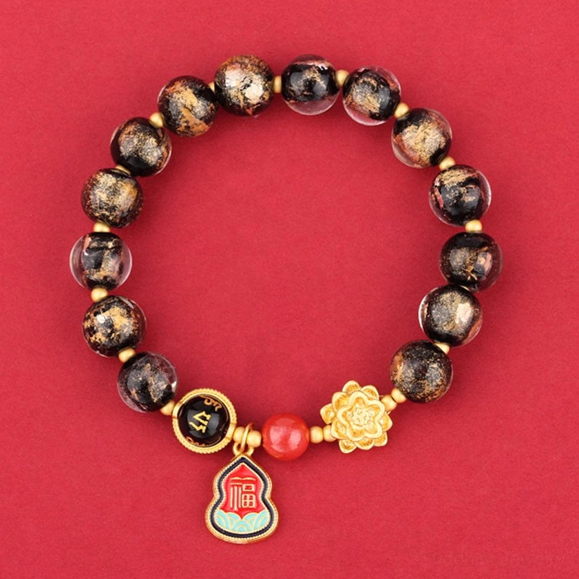 Black Liuli glass Buddhist bracelet with Om Mani Padme Hum charm, lotus pendant, and Fu character gourd on red background