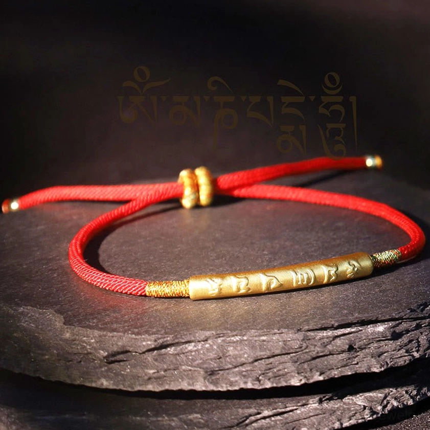 Om Mani Padme Hum bracelet flat lay with adjustable knot and gold-engraved tube on stone slab background