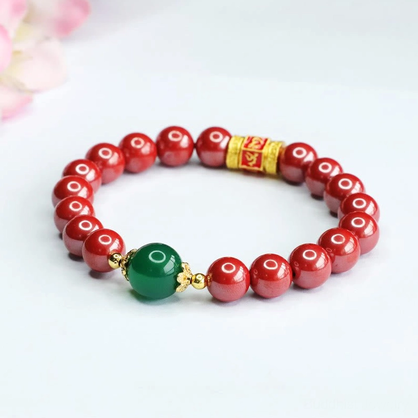 Om Mani Padme Hum Buddhist bracelet with smooth red cinnabar beads and green agate bead on neutral background