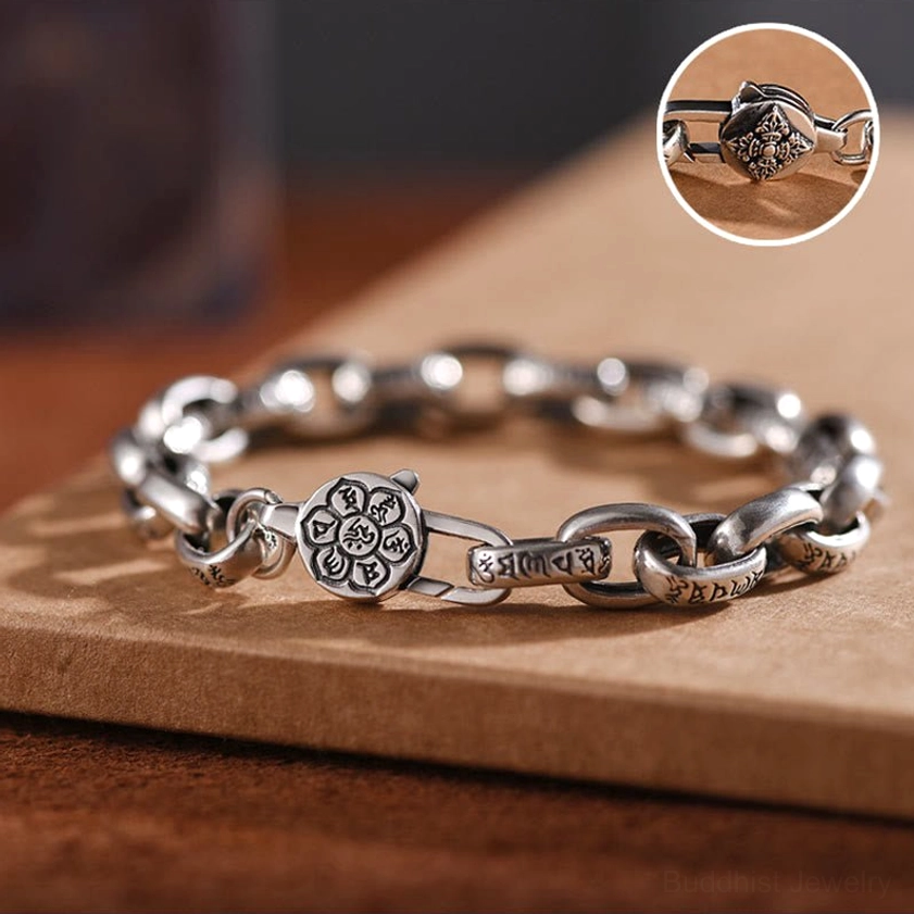 Six true words buddhist silver bracelet close-up showing ornate engraved clasp detail and linked chain segments on wooden background