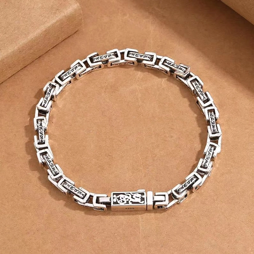 Om Mani Padme Hum mantra engraved copper bracelet overhead close-up detail of sacred script links