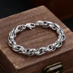 Om Mani Padme Hum carved copper bracelet with antique silver finish, top-down view showing intricate engraved mantra detail